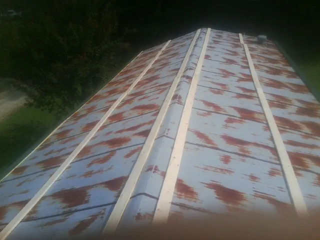 Rusted metal roof panels with new wood purlins before replacement — Storm Damage Roof Repair in Battle Creek by Roofing Brothers